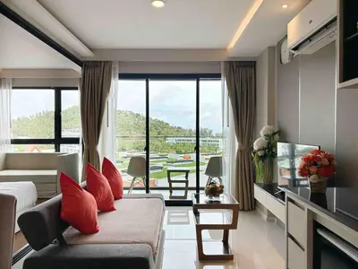 a living room with a couch and a large window at Seaview, cozy apartment, Surin in Surin Beach
