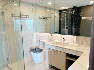 a bathroom with a toilet and a glass shower at Seaview, cozy apartment, Surin in Surin Beach