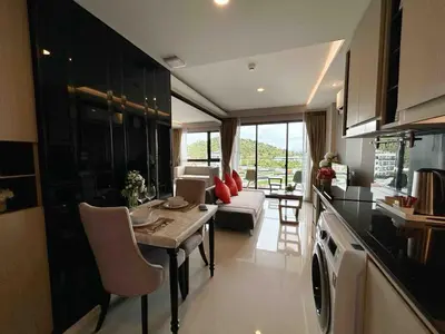 a kitchen and living room with a table and a couch at Seaview, cozy apartment, Surin in Surin Beach