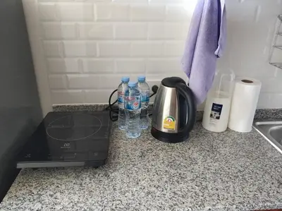 a coffee maker and water bottles on a kitchen counter at Lovely Mai Khao studio room in Mai Khao Beach