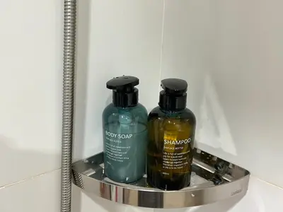 two bottles of soap on a shelf in a bathroom at Serene Panwa beachfront in Ban Ao Makham