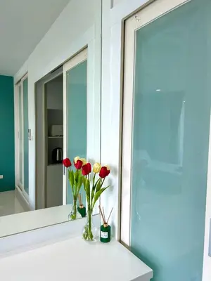 a vase of flowers on a counter in front of a mirror at Serene Panwa beachfront in Ban Ao Makham