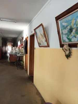 a hallway with paintings on the wall and a table at Suksabai Hotel Phuket in Phuket Town