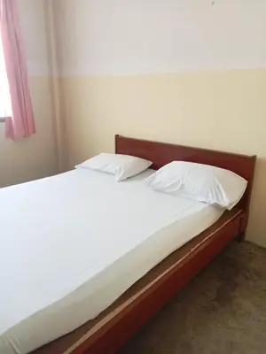 a bed with two pillows on it in a room at Suksabai Hotel Phuket in Phuket Town