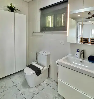 a white bathroom with a toilet and a sink at Villa Miyoko Ko Yao Noi Enjoy nature's beauty and stunning sunsets in Ko Yao Noi