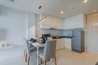 a kitchen with a table and chairs and a refrigerator at Brand New 2 Bed Seaview Apartment Utopia Karon in Karon Beach