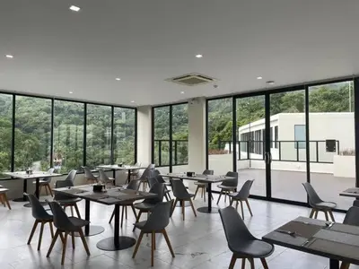 a restaurant with tables and chairs and large windows at Brand New 2 Bed Seaview Apartment Utopia Karon in Karon Beach