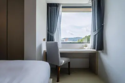a bedroom with a desk and a chair and a window at Brand New 2 Bed Seaview Apartment Utopia Karon in Karon Beach