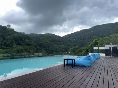 a large swimming pool with a table and a blue raft at Brand New 2 Bed Seaview Apartment Utopia Karon in Karon Beach