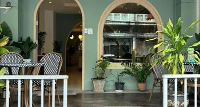 a restaurant with two tables and chairs and plants at Eco Phuket old town in Ban Lo Long