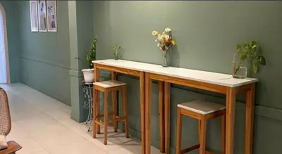 a bar with two stools and a vase of flowers at Eco Phuket old town in Ban Lo Long