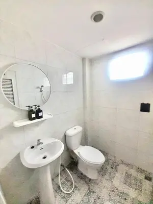 a white bathroom with a toilet and a sink at Eco Phuket old town in Ban Lo Long