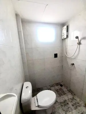 a bathroom with a white toilet and a window at Eco Phuket old town in Ban Lo Long