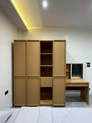 an empty room with wooden cabinets and a television at P One Apartments in Phuket Town