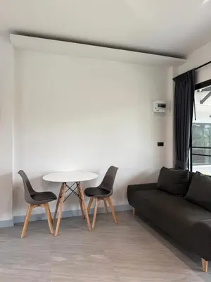 a living room with a couch and a table and chairs at P One Apartments in Phuket Town