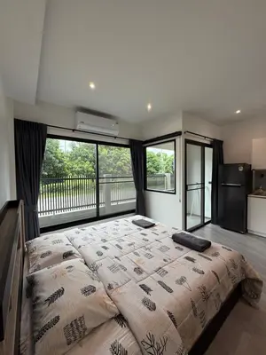 a bedroom with a large bed with a large window at P One Apartments in Phuket Town