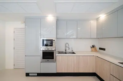 a kitchen with white cabinets and stainless steel appliances at Anchan Villas Phuket - 4 BR Signature Pool Villa by Escape Villas in Ban Phru Champa