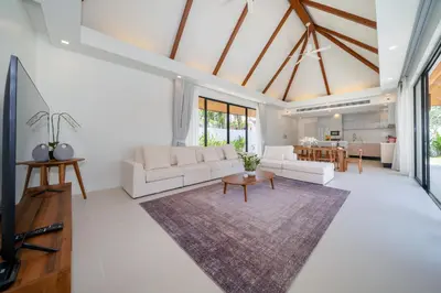 a living room with a couch and a table at Anchan Villas Phuket - 4 BR Signature Pool Villa by Escape Villas in Ban Phru Champa