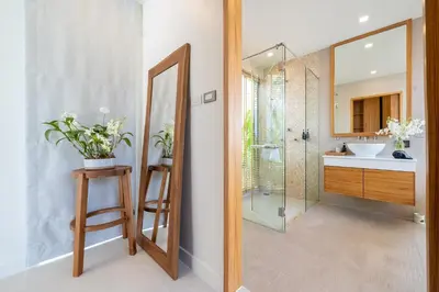 a bathroom with a sink and a shower with a mirror at Anchan Villas Phuket - 4 BR Signature Pool Villa by Escape Villas in Ban Phru Champa