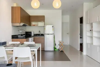a kitchen with a refrigerator and a table and chairs at The Lago by Villacarte in Rawai Beach