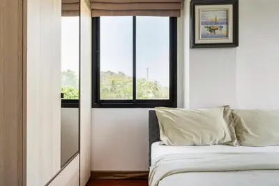 a bedroom with a bed and a window at The Lago by Villacarte in Rawai Beach