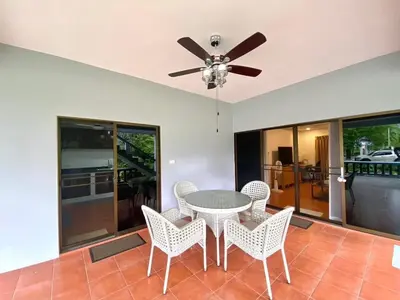 a dining room with a ceiling fan and a table and chairs at Cozy Space Kamala in Kamala Beach