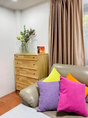 a couch with colorful pillows in a living room at Cozy Space Kamala in Kamala Beach