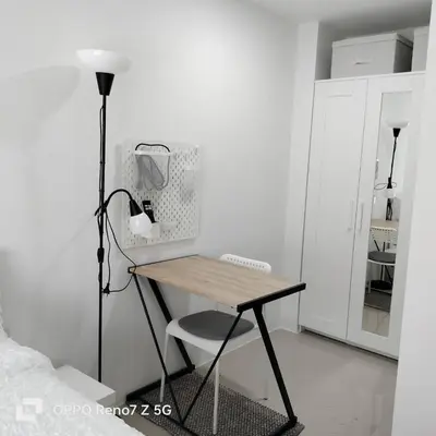 a desk with a chair and a lamp in a room at The Urban Tropical Apartments in Mai Khao Beach