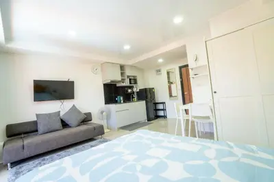 a living room with a bed and a couch at The Urban Tropical Apartments in Mai Khao Beach