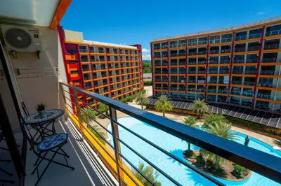 a balcony with a view of a pool and buildings at The Urban Tropical Apartments in Mai Khao Beach