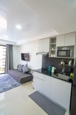 a kitchen and a living room with a couch at The Urban Tropical Apartments in Mai Khao Beach