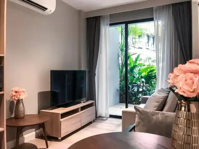 a living room with a tv and a couch and a table at Cozy apartment Banggtao beach in Bang Tao Beach