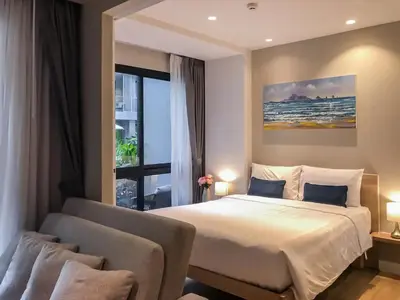 a bedroom with a bed and a couch and a window at Cozy apartment Banggtao beach in Bang Tao Beach