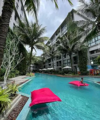 a swimming pool with two red pillows in a resort at Cozy apartment Banggtao beach in Bang Tao Beach