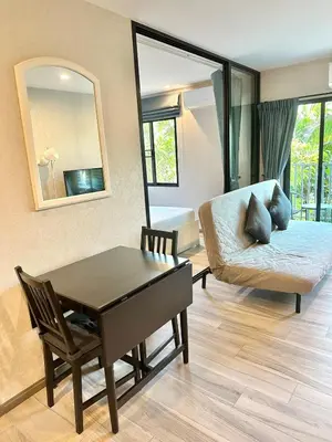 a living room with a couch and a table and a mirror at Condo of Light Swimming Pool in Ban Bo Han