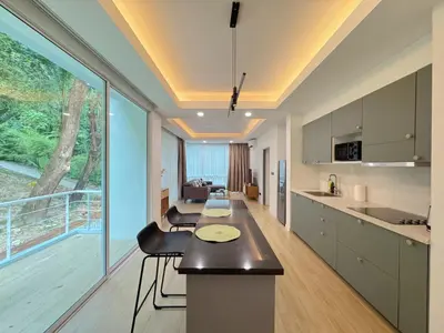 a kitchen with a table and a large window at Tropical Living Kamala Hillside in Kamala Beach
