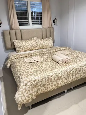 a bed with two towels on it in a bedroom at Miley Guesthouse in Phi Phi Don