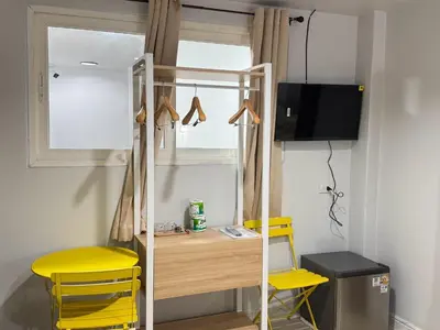 a room with a desk and two yellow chairs at Miley Guesthouse in Phi Phi Don