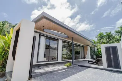 a home with a large window and a patio at Pangolin villa Nai Thon Beach in Nai Thon Beach