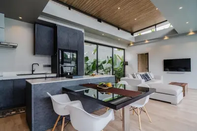 a kitchen and living room with a table and chairs at Pangolin villa Nai Thon Beach in Nai Thon Beach