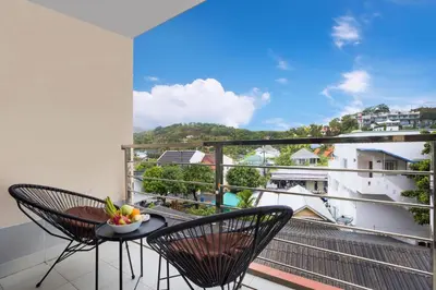 a balcony with two chairs and a table with a view at Rawai Apartment RBC 311, near Famous Rawai Market in Phuket Town