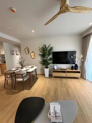 a living room with a dining table and a tv at Laguna Beachside Residences 2bdr in Ban Thalat Choeng Thale