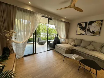 a living room with a couch and a table at Laguna Beachside Residences 2bdr in Ban Thalat Choeng Thale