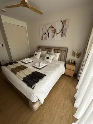 a bedroom with a large white bed with two dishes on it at Laguna Beachside Residences 2bdr in Ban Thalat Choeng Thale