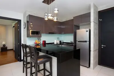 a kitchen with a black counter and a refrigerator at Stylish Stay, Quiet Vibe - Apartment RGN B411 in Bangtao in Bang Tao Beach