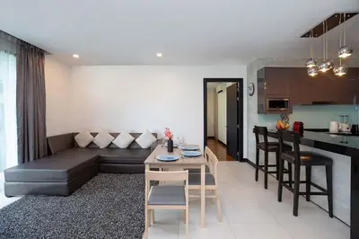 a living room and kitchen with a couch and a table at Stylish Stay, Quiet Vibe - Apartment RGN B411 in Bangtao in Bang Tao Beach