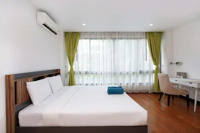 a bedroom with a bed with a desk and a window at Stylish Stay, Quiet Vibe - Apartment RGN B411 in Bangtao in Bang Tao Beach
