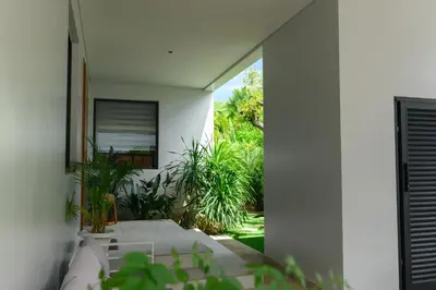 a white house with a courtyard with plants at Botanica Modern Loft by RESAVA in Bang Tao Beach