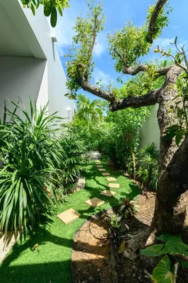 a garden with green grass and a tree at Botanica Modern Loft by RESAVA in Bang Tao Beach