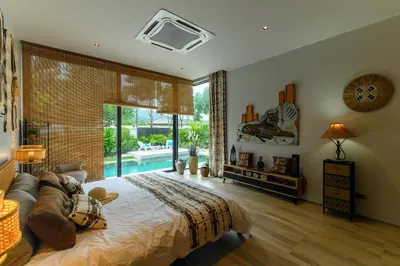 a bedroom with a large bed and a pool at Botanica Modern Loft by RESAVA in Bang Tao Beach